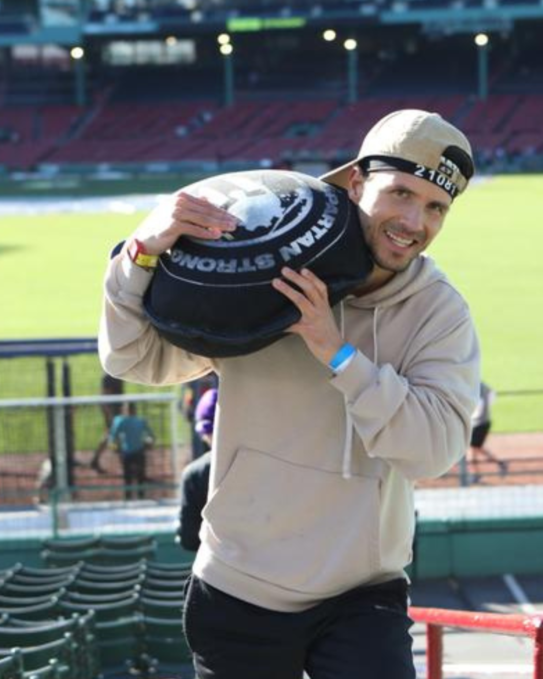 Alex Blakeslee carrying a Spartan training sandbag at Fenway Park